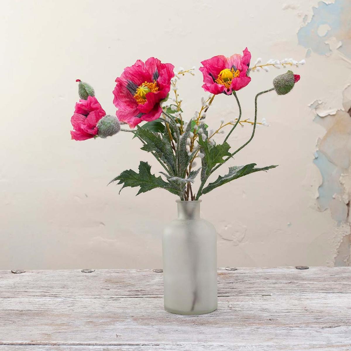 Poppies and Foliage in a Frosted Bottle Vase by Peony - Fuchsia Pink with yellow centres and green leaves – image 1