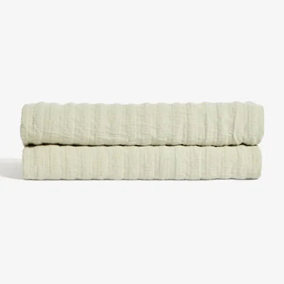 Kave Home Rilune 100% cotton bedspread with light green embossed stripe effect for convertible cot
