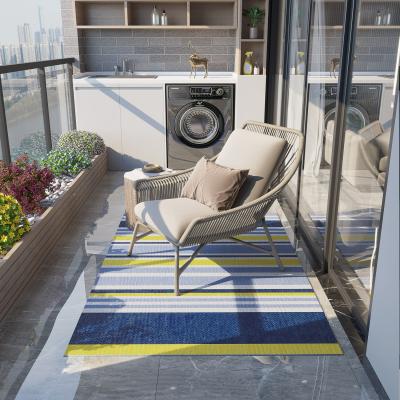 The Range Reversible Outdoor Rug, Waterproof Plastic Straw Mat  - Dark blue, light blue, yellow, and white strips